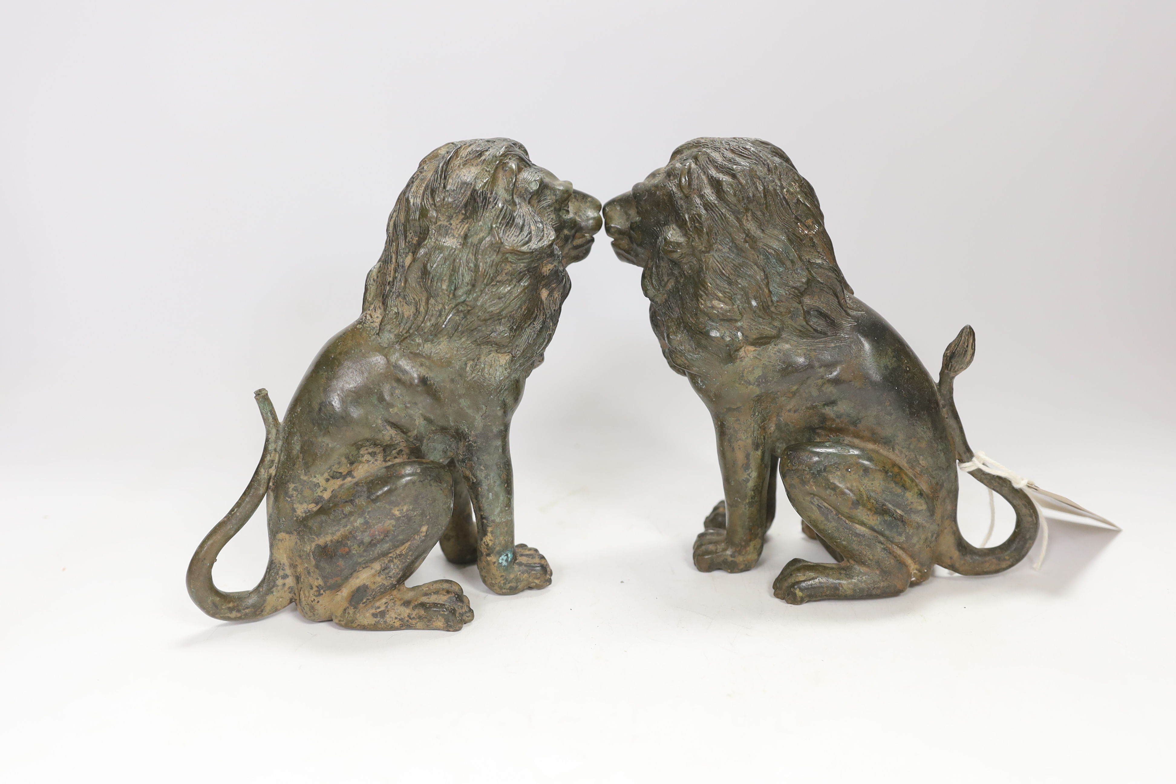 A pair of bronze models of seated lions, 17cm